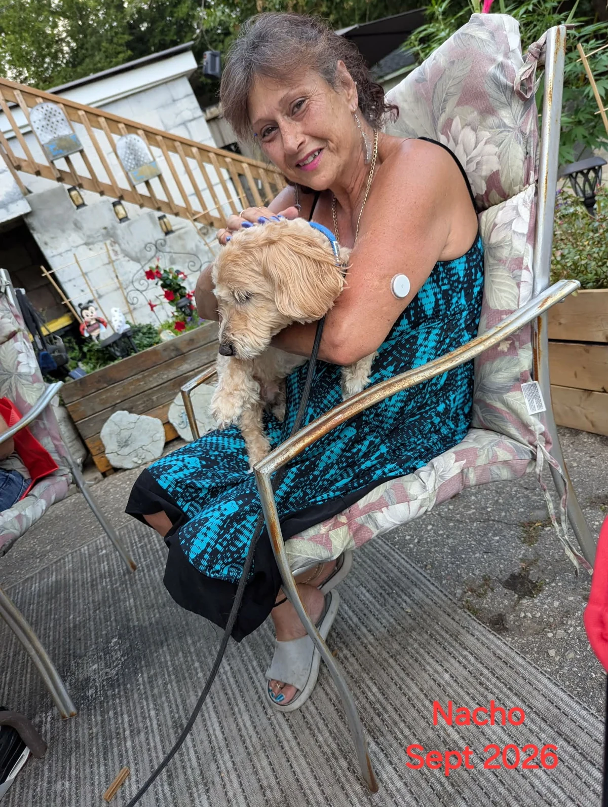 Norma cuddling a dog outdoors at Gucci Goo